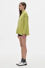 Sweater tejido color borgoña con cuello alto, corte oversize y mangas largas con detalle de trenzas verticales.