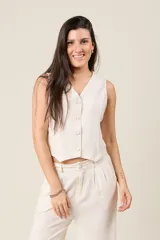 Chaleco negro cropped de lino, con escote en V y cierre frontal con botones.