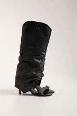 Botas de cuero negro, con sandalias de tiras finas y taco aguja.