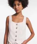 Chaleco color crema con finas rayas verticales rosadas, escote cuadrado, breteles anchos, abotonado frontal y bajo asimétrico.