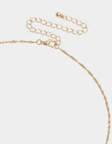 Cadena corta dorada con dije de moño con piedras de zirconia y dije de corazón colgante.