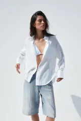 Camisa color durazno confeccionada en algodón, de corte amplio, con cuello solapa, manga larga con puños abotonados, hombros caídos, bolsillo de parche en el pecho, pinzas en la espalda y cierre frontal con botones.