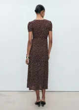 Vestido midi marrón con estampado de lunares blancos, escote en V, mangas cortas abullonadas y corte entallado.