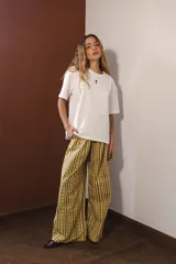 Pantalón palazzo con estampado a rayas verticales marrones y amarillas.