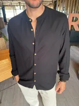 Camisa negra de lino con cuello mao, manga larga y abotonadura frontal con botones de madera.