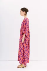 Vestido largo de viscosa estampada en tonos naranja y violeta. Tiene mangas al codo, calce holgado y recorte en la cintura con frunces.