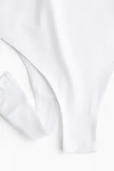 Body blanco colaless de punto elástico suave con escote redondo, sin mangas y botones a presión ocultos en la entrepierna.