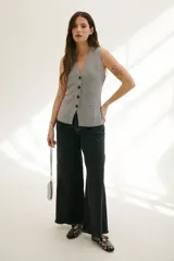 Pantalón de jean acampanado color caramelo con cintura alta y cinturón marrón con tachas.