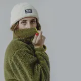 Buzo de polar verde oliva con corte a la altura del pecho en tela lisa color verde militar. Cierre frontal con cremallera amarilla y bolsillo tipo canguro con etiqueta de la marca.