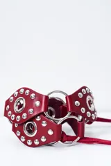 Cinto de cuero color bordó con tachas plateadas y argollas metálicas.