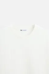 Camiseta negra de corte holgado, con cuello redondo y mangas cortas.