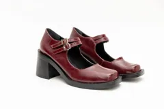 Guillermina de cuero negro con punta cuadrada, taco bloque y correa sobre el empeine con hebilla dorada.