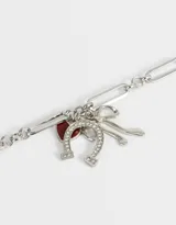 Collar dorado con cadena de eslabones grandes y dijes colgantes de corazón rojo, herradura y moño con strass.