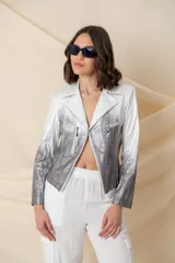 Chaqueta corta de cuero ecológico con diseño degradado de blanco a gris. Tiene cuello tipo solapa, cierre frontal asimétrico con broche y bolsillos con cierre.