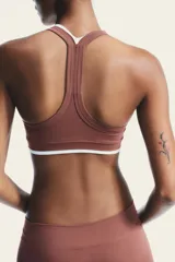 Top deportivo color ladrillo con escote redondo y tirantes blancos.