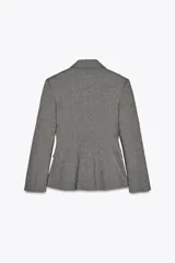 Blazer gris jaspeado de cuello solapa y manga larga con hombreras. Tiene bolsillos delanteros con solapa y cierre frontal cruzado con botones.