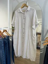 Vestido camisero color verde lima, de lino, con cuello camisero, mangas cortas y cierre frontal con botones.