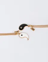 Set de dos collares dorados con dijes de yin yang esmaltados en blanco y negro, con detalle de strass y dije con la inscripción "BFF".