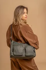 Bandolera de tafeta impermeable, liviana, con dos compartimientos principales, dos bolsillos con cierre y correa regulable con hebilla.