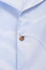 Camisa estilo camper, de fit boxy, confeccionada en popelina con estampa de mármol celeste y blanco. Tiene cuello tipo camp-collar y botones de madera.