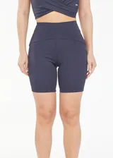 Calza biker deportiva de cintura alta color gris, con compresión, recortes y tejido transpirable de secado rápido.