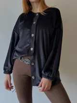 Sobrecamisa negra de plush con mangas abullonadas y cierre frontal con botones.