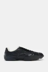 Zapato deportivo estilo running color negro con detalle de acolchado en el cuerpo, suela con relieve, cierre mediante cordones y lengüeta.