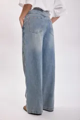 Pantalón jean celeste de corte ancho con detalle de franja lateral azul oscuro.