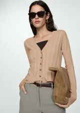 Cárdigan color beige de tejido de punto fino con cuello pico, diseño recto, cierre delantero con botones y manga larga.