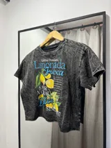 Remera negra jaspeada de corte cropped con estampa de la portada de la revista Vogue con imagen de Frida Kahlo intervenida con un rayo azul.