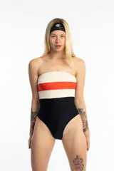 Malla enteriza strapless con diseño tricolor: blanco texturizado en la parte superior, franja naranja en el medio y negro en la parte inferior. Incluye breteles desmontables de lycra.