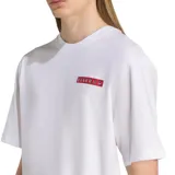 Remera blanca de manga corta con cuello redondo y un pequeño logo rectangular rojo en el pecho.