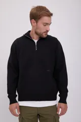 Sweater negro de punto con cuello alto y cierre de cremallera parcial.