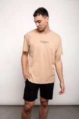 Remera beige con estampado de texto en el pecho.