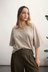 Remera color crema de corte holgado, con mangas cortas y cuello redondo.