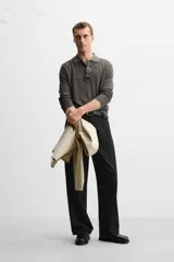 Polo de hombre color gris oscuro, de punto ligero tejido en hilatura con mezcla de seda y algodón. Tiene cuello solapa con cierre frontal de botonadura, manga larga y acabados en rib.