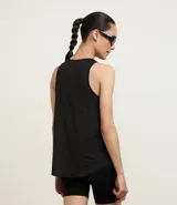 Musculosa deportiva color crema confeccionada en microfibra texturizada con diseño de cuadraditos, cuello redondo, bretel ancho y bajo redondeado.