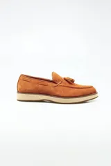 Mocasines color marrón claro, de gamuza, con borlas y suela de goma.