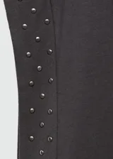 Camiseta gris de algodón con cuello redondo y mangas cortas con tachas plateadas en los hombros.
