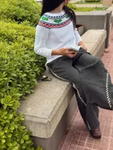 Sweater tejido blanco de hilo 100% algodón, con cuello redondo y diseño con motivos geométricos en el canesú en tonos rojo, verde, azul y negro.