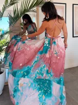 Vestido largo de tela fluida, color verde esmeralda con estampado abstracto en tonos turquesa y detalles dorados. Diseño asimétrico con un solo tirante tejido en el hombro.