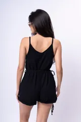 Mono corto blanco con breteles finos, escote en V y cinturón con hebilla circular.