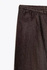 Pantalón palazzo color ladrillo, confeccionado en lino 100%, de tiro medio, cintura ajustable con cordones, bolsillos laterales ocultos y pierna ancha.
