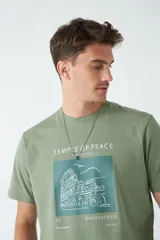 Remera verde militar de algodón con estampa en el frente con la frase "Temple of Peace" y un dibujo de un edificio.