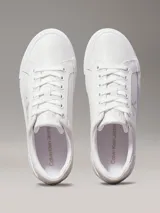 Zapatillas urbanas Calvin Klein Jeans de cuero sintético color blanco, con plataforma plana, cordones y logo CK en el lateral.
