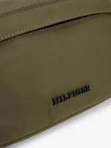 Cartera bandolera Tommy Hilfiger color verde militar, con correa ajustable negra, bolsillo frontal con cierre y logo de la marca en el frente.