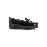 Mocasín de cuero charol negro con plataforma blanca y detalle de hebilla metálica plateada en el empeine.
