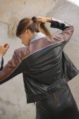 Campera tipo moto con cuello mao en platino suave y combinación de tres tonos de cuero ovino: negro, marrón rojizo y plateado. Forrada con cierres en las mangas.