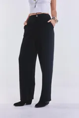 Pantalón negro de lino, de corte amplio, con pretina de botón y cierre. No tiene lycra.