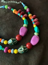 Collar corto con cuentas de cerámica, resina y piedras de colores. Cierre con cadena de acero quirúrgico y gancho para regular el largo.